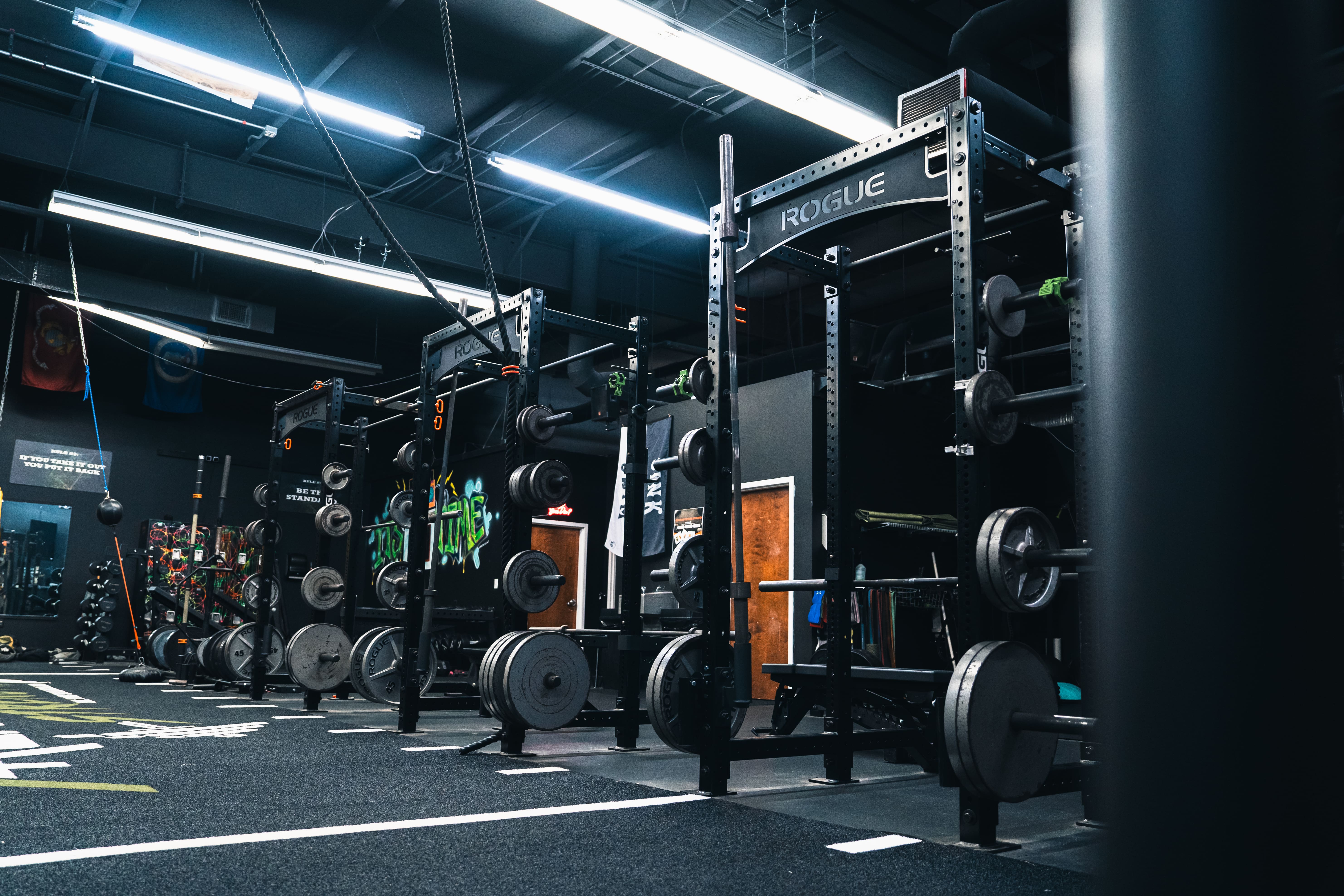 Loaded barbells and calibrated plates at Archetype Strength powerlifting gym, Raleigh NC